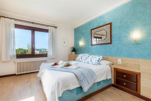 a bedroom with a bed with a blue wall at Es Pujols in Artá