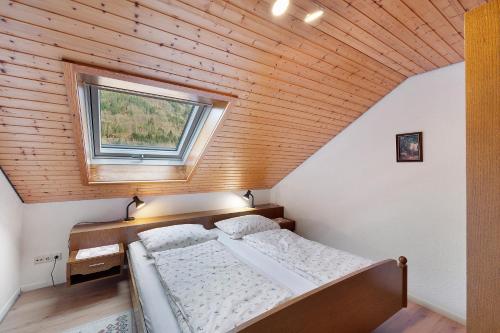 a small bedroom with a bed and a window at Haus Huber in Wolfach