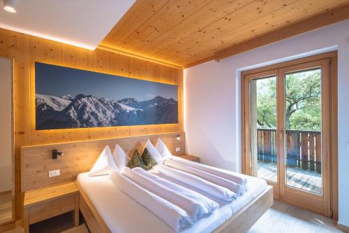 a bedroom with a large bed with a large window at Kriendl Nr 2 in Valdaora
