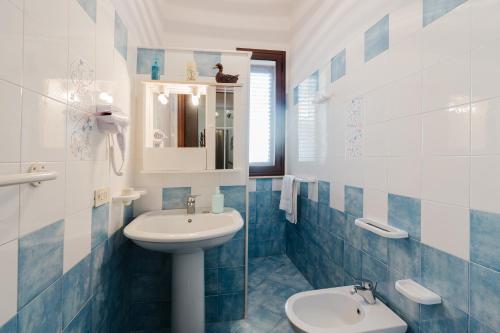 a blue and white bathroom with a sink and a toilet at Casa La Piazzetta in Marsala