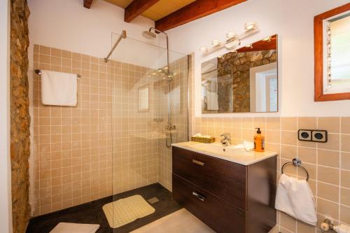 a bathroom with a sink and a shower with a mirror at La Fortaleza in Pollença