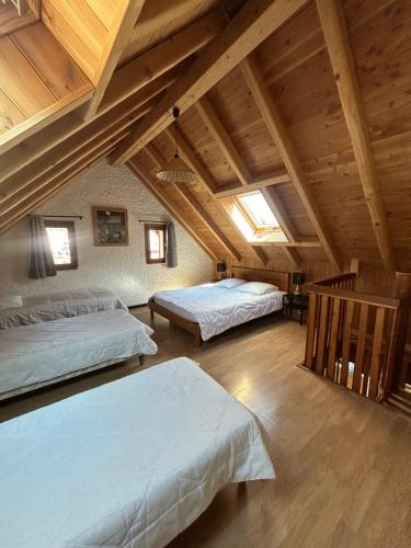 two beds in a attic room with wooden ceilings at Chalet Moulinot in Valloire