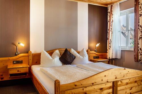 a bedroom with a wooden bed with white pillows at Wein- und Gästehaus Lutz in Iphofen