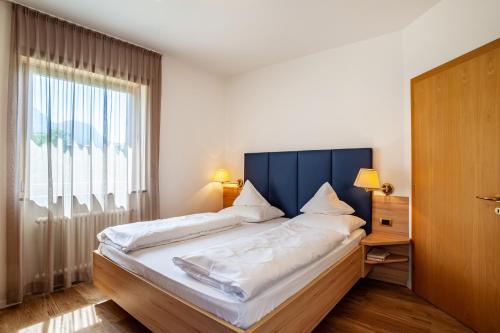 a bedroom with a large bed with a large window at Gartenheim App Leonhard in Schenna