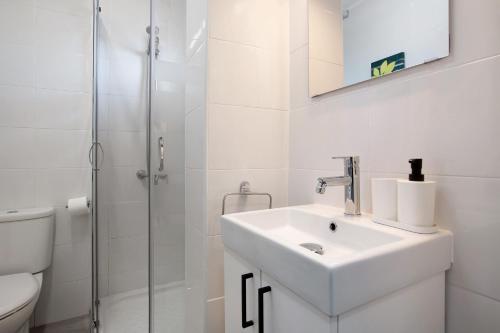 a white bathroom with a sink and a shower at Apartamento Saltillo Alto in Torremolinos