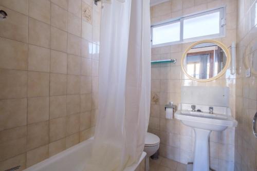 a bathroom with a sink and a toilet and a mirror at Apartamento las Palmeras 4 in Benicarló