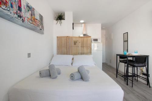 a bedroom with a white bed and a desk at Apartamento Saltillo Alto in Torremolinos