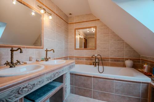 a bathroom with two sinks and a tub at Courseulles Comme À La Maison in Courseulles-sur-Mer
