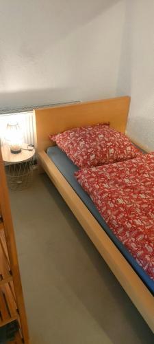 a bed with a red comforter and a table at Peter in Michelstadt