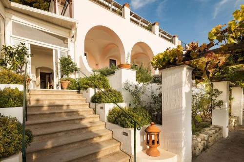 a white house with stairs and plants at Tenuta Del Poggio Antico in Ischia