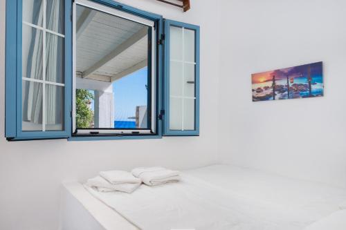 a bathroom with a window and two towels on a counter at Beachfront Lampis Dolphin 2 in Skala