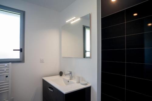 a bathroom with a sink and a mirror at Villa Surf and Golf in Messanges