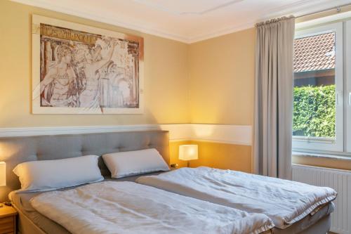 a bedroom with a bed with a painting on the wall at Haus Hafenblick in Walchum
