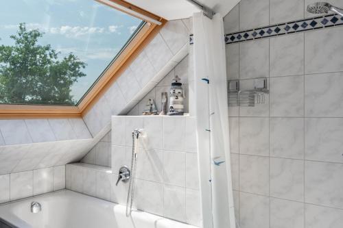 a bathroom with a shower and a tub at Haus Hafenblick in Walchum