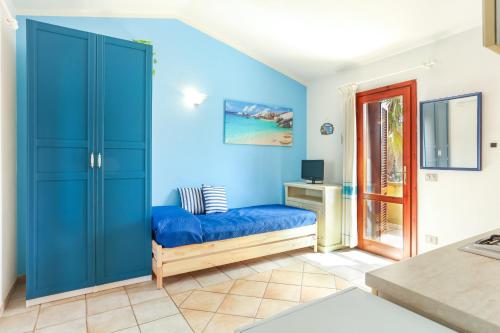 a room with blue walls and a blue couch at Bilocale Geranium Beach in San Teodoro