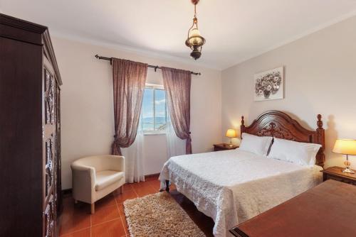 a bedroom with a bed and a chair and a window at Casa Da Jesus in Provesende