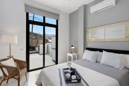 a bedroom with a bed and a chair and a window at Urban Park Aloe in Los Llanos de Aridane