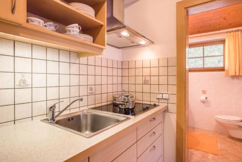 a kitchen with a sink and a toilet at Kuglerhof Apt 2 in Cadipietra