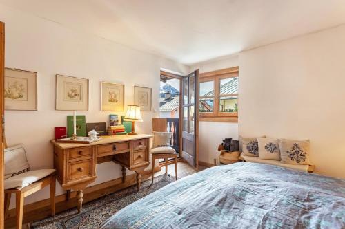 a bedroom with a bed and a desk and a window at Ferienappartement 1 - Lockstein in Berchtesgaden