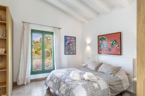 a bedroom with a bed and a window at Sa Verdal in El Port de la Selva