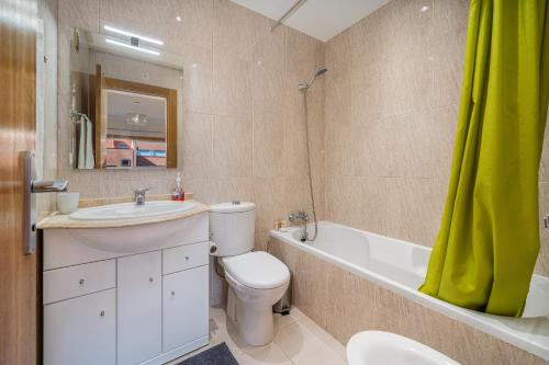 a bathroom with a sink and a toilet and a bath tub at Paraíso da Rocha in Portimão