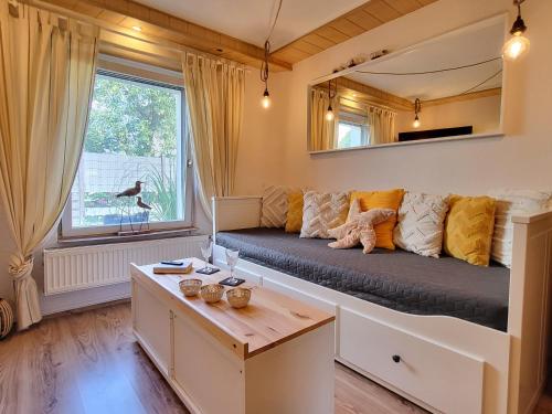 a living room with a couch and a window at Mien lüttes Glück -Fewo Backboord in Zempin