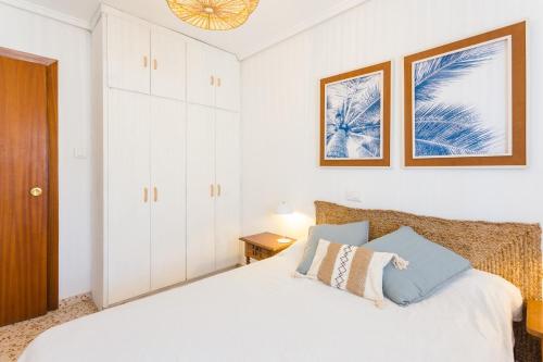 a white bedroom with a bed and a closet at Palmera Beach House in Cullera