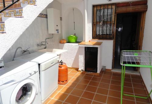 a washing machine in a kitchen with a staircase at El Rafalet in Jávea
