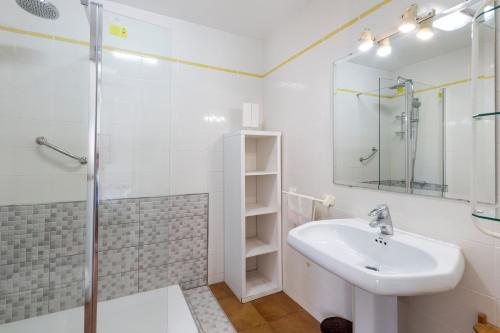 a white bathroom with a sink and a shower at La Gola in La Manga del Mar Menor