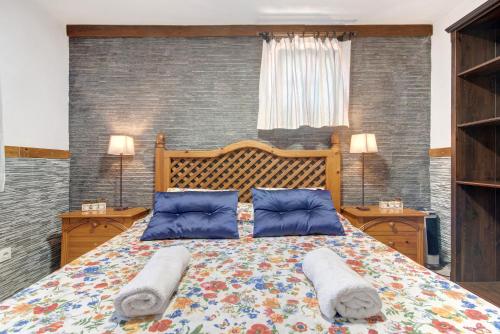 a bedroom with a large bed with two pillows at Villa La Quinta de Vals in Valsequillo