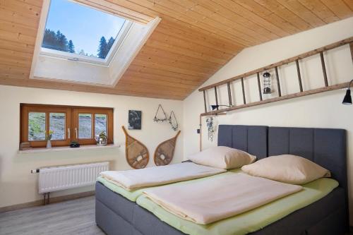 a bedroom with a bed in a room with windows at Weitsicht in Weiler-Simmerberg