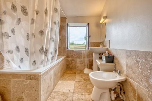 a bathroom with a tub and a toilet and a sink at Le Chai in Razac-dʼEymet