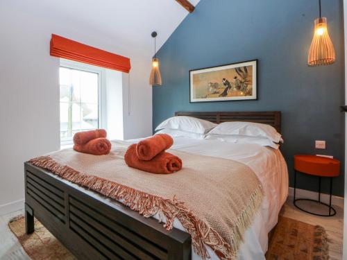 a bedroom with a bed with towels on it at East meets West in Criccieth