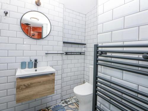a white bathroom with a sink and a mirror at East meets West in Criccieth
