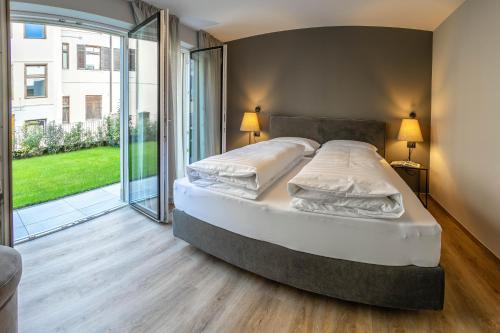 a large bed in a bedroom with a large window at Lores Loft in Merano