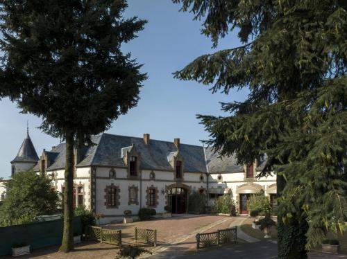 a large white house with trees in the foreground at Domaine du Boisniard in Chambretaud