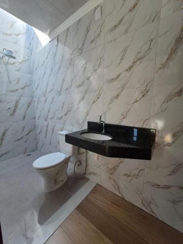 a bathroom with a sink and a toilet at Casa com piscina em Maringá in Maringá