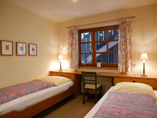 a bedroom with two beds and a desk and a window at Ferienhaus Straubehof in Sasbachwalden
