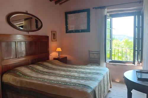 a bedroom with a bed with a mirror and a window at Villa con parco e piscina-Camaiore in Nocchi