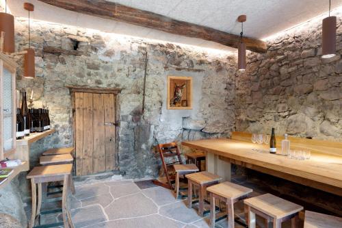 a room with a stone wall with a wooden table and chairs at Rielingerhof in Collalbo
