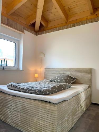a large bed in a room with a wooden ceiling at Villa Toscana in Teltow