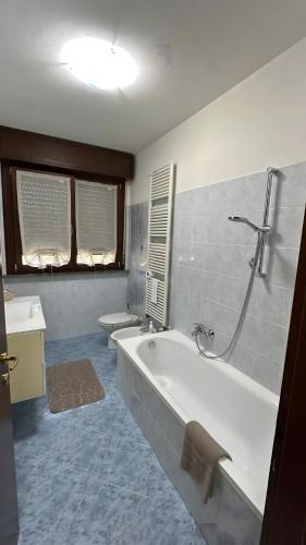 a bathroom with a tub and a sink and a toilet at Appartamento Ely in Pioltello