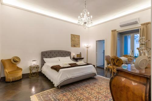 a bedroom with a bed and a table and chairs at Dimora D'Incanto in Ragusa