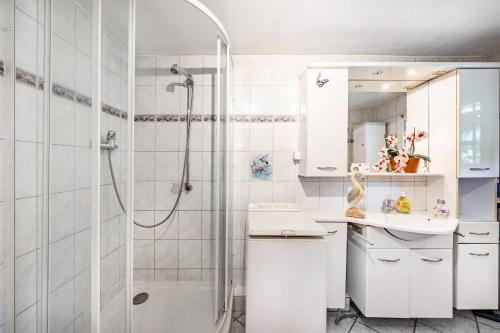 a white bathroom with a shower and a sink at Fewo mit Terrasse Moritzburg in Moritzburg