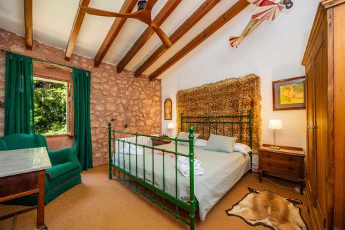a bedroom with a bed and a chair in a room at Sa Cabana d'es Vicari in Fornalutx