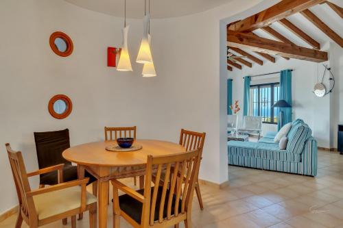 a dining room and living room with a table and chairs at Villa Amalia in Denia