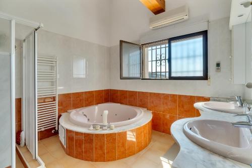 a large bathroom with a tub and two sinks at Villa Amalia in Denia