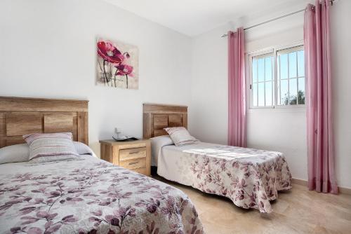 a bedroom with two beds and a window at Chalet Rural El Chorrillo in Conil de la Frontera
