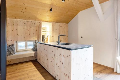 a kitchen with a sink and a couch in a room at Ferienwohnung Lavendel Thalerhof in Ponte Nova