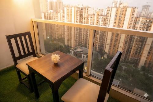 a table and chairs in a room with a large window at Lux 1bhk with balcony in Noida